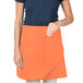 A woman wearing an orange Intedge waist apron.