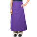 A woman wearing a purple Intedge bistro apron with 2 pockets.
