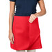 A woman wearing a red Intedge 4-way waist apron with pockets.