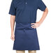 A man wearing a navy blue Intedge waist apron over a blue shirt.