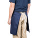 A man wearing a navy blue Intedge waist apron.