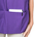 A purple and white Intedge cobbler apron with pockets.