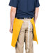 A person wearing a yellow Intedge waist apron.