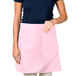 A woman wearing a pink Intedge waist apron.