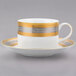 A close-up of a white and gold teacup and saucer.