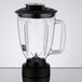 A clear Waring blender jar with a black lid and base.