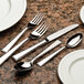 A set of Libbey stainless steel teaspoons on a marble surface.