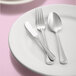 A white plate with Libbey stainless steel extra heavy weight dinner forks on it.