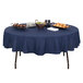 A Correll round folding table with mocha granite finish set with food on a blue tablecloth.