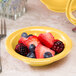 A Libbey Cantina saffron porcelain fruit bowl filled with berries on a table.