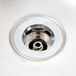 A close-up of a stainless steel sink drain.