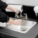 A person using a Cambro CamKiosk portable hand sink with a granite gray door.