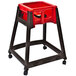 A brown Koala Kare high chair with red seat and black casters.