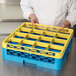 A person holding a blue and yellow plastic container with a yellow Carlisle glass rack extender.