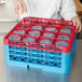 A woman using a Carlisle red color-coded glass rack to store clear glasses.
