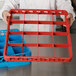 A chef holding a red Carlisle glass rack extender.