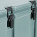 A close-up of a black plastic latch on a blue Cambro insulated soup carrier.