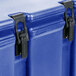 A close-up of a navy blue Cambro insulated soup carrier with black metal latches.
