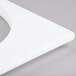 A white plastic triangle with four small holes.