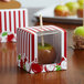 A Baker's Mark red and white striped candy apple box with a window containing a candy apple.