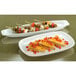 Two Libbey ultra bright white porcelain coupe platters with skewers of peppers on them.