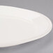 An oval ivory porcelain platter with a rim.