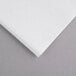 A close up of an Ultra Premium Jumbo Fold white paper towel on a gray surface.