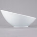 A close-up of a Libbey white porcelain Belmar bowl with a curved bottom.