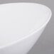A close up of a Libbey white porcelain Belmar bowl with a curved edge.