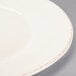 A close up of a Libbey Farmhouse ivory porcelain plate with a wide rim.