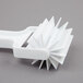 A white plastic bear claw cutter with a white handle.