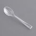 A clear plastic Visions tasting spoon on a gray surface.