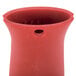 A red silicone pot holder with a hole in the bottom.