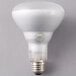 A Satco BR30 halogen light bulb with a white base on a gray surface.