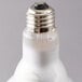 A close up of a Satco halogen flood light bulb with a white light.