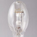 A close-up of a clear Satco metal halide light bulb with a wire inside.