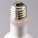A close up of a Satco 45 watt frosted halogen light bulb with a small hole in it.