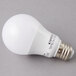A Satco frosted warm white LED light bulb on a gray surface.