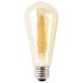 A close-up of a Satco transparent amber LED light bulb with a clear light bulb inside.