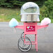 A pink Carnival King cotton candy cart with a white shelf attached to the left wheel.