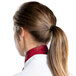 The back of a woman's head wearing a burgundy chef neckerchief with a ponytail.