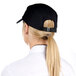 A woman wearing a black Headsweats 5-panel cap with a ponytail.