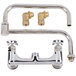 A T&S chrome wall mounted faucet with two brass handles and a hose.