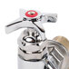 A T&S chrome wall mount faucet with red handles.