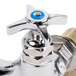 A chrome T&S wall mounted faucet with blue knobs.