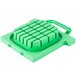 A green plastic square with a square grid and a handle.