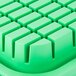 A close-up of a green rectangular plastic tray with squares.