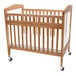 A wooden L.A. Baby crib with wheels.