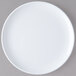 A Carlisle white melamine plate with a white rim on a gray surface.