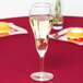 A Libbey tulip champagne glass filled with champagne on a table.